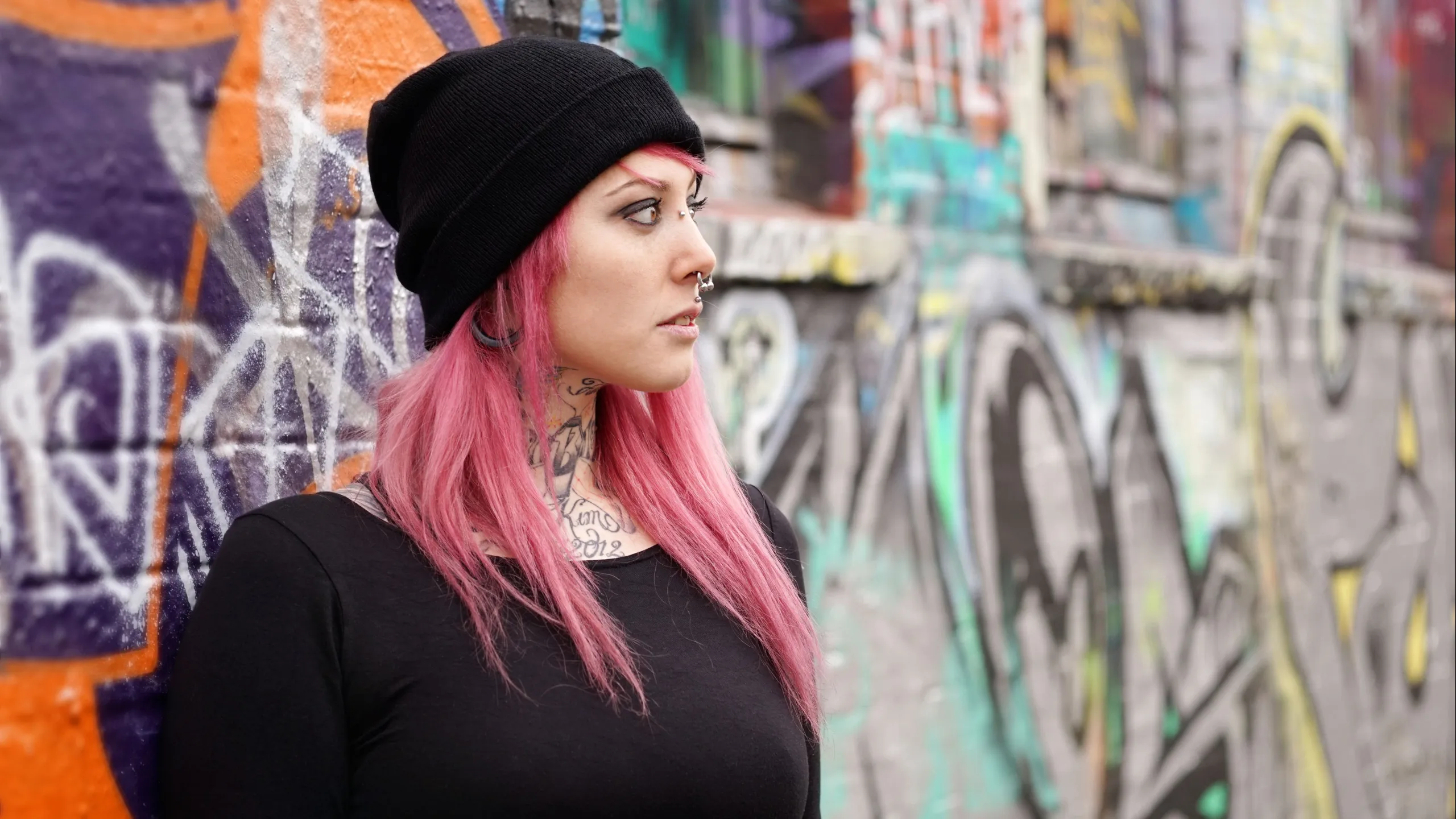 Eine Frau steht an einer Graffiti - Wand
