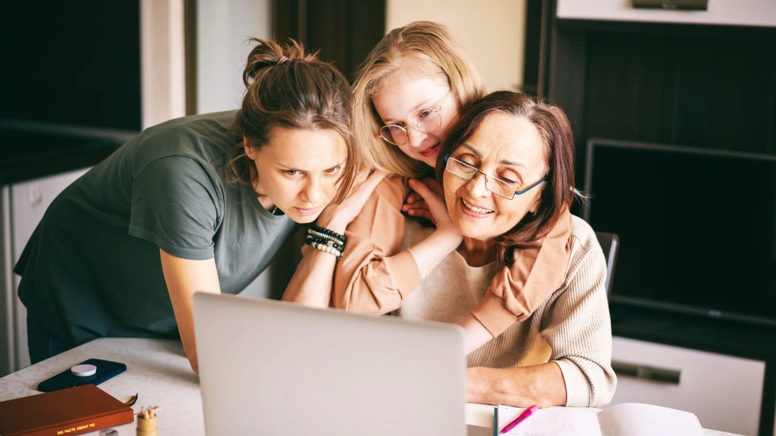 Eine Frau schaut mit zwei Kindern in einen Laptop.